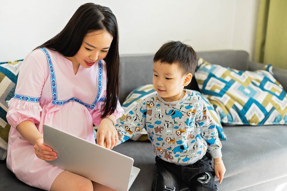 pregnant woman working from home with kid