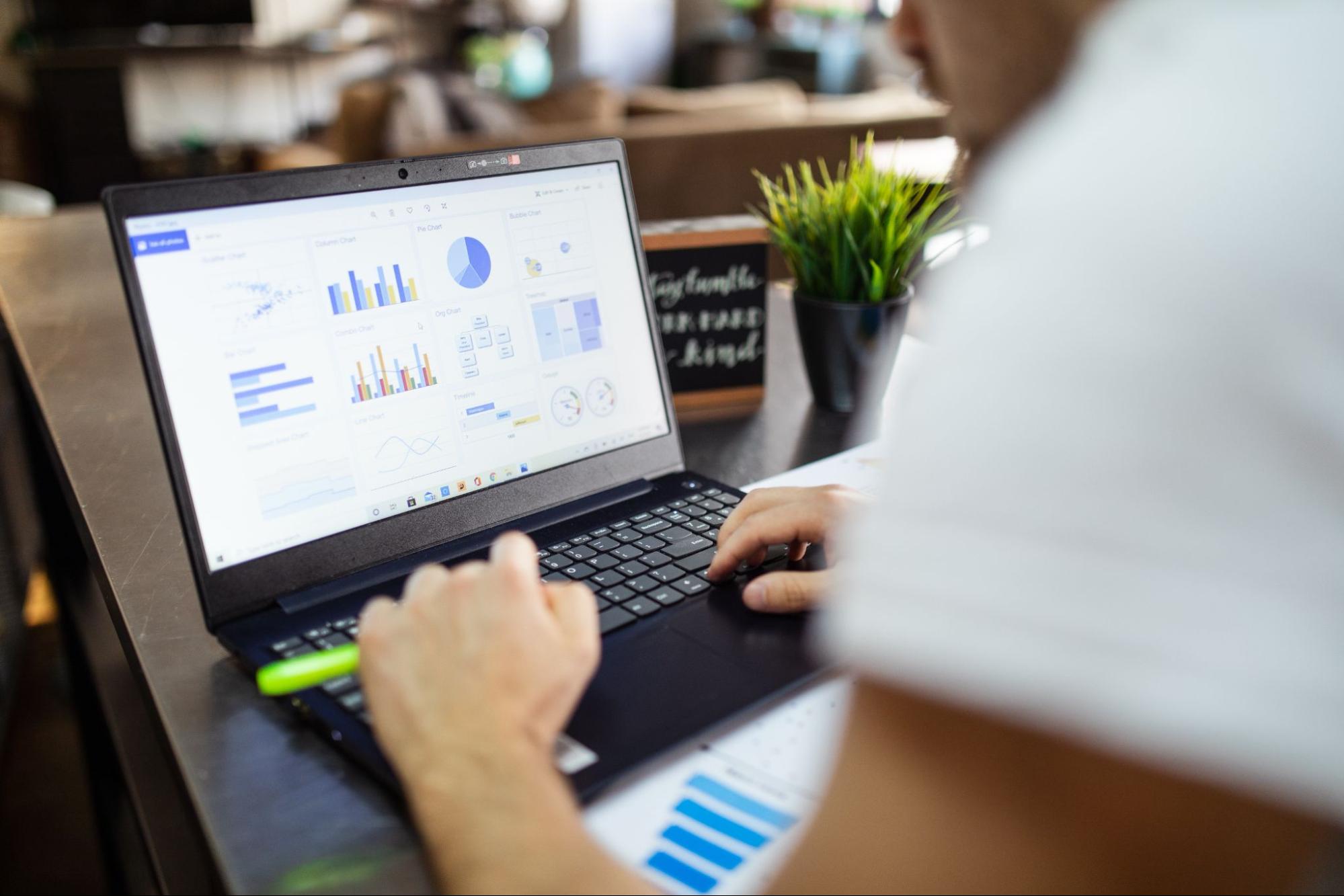 employees with laptops and looking over charts