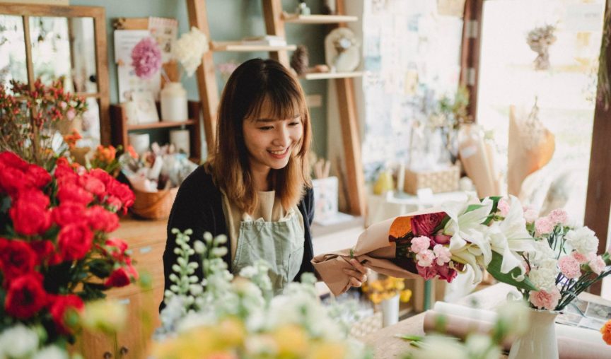 woman wrapping a bunch of flowers at a florist