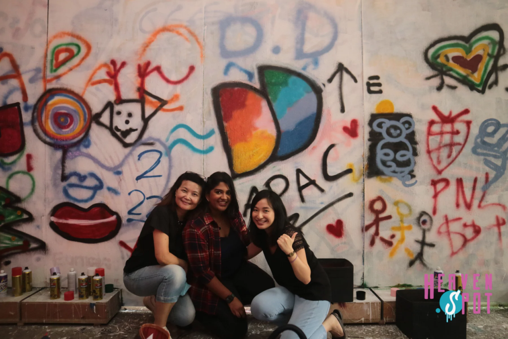 Colleagues posing in front of a graffiti wall