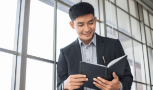 man smiling and looking at a notebook