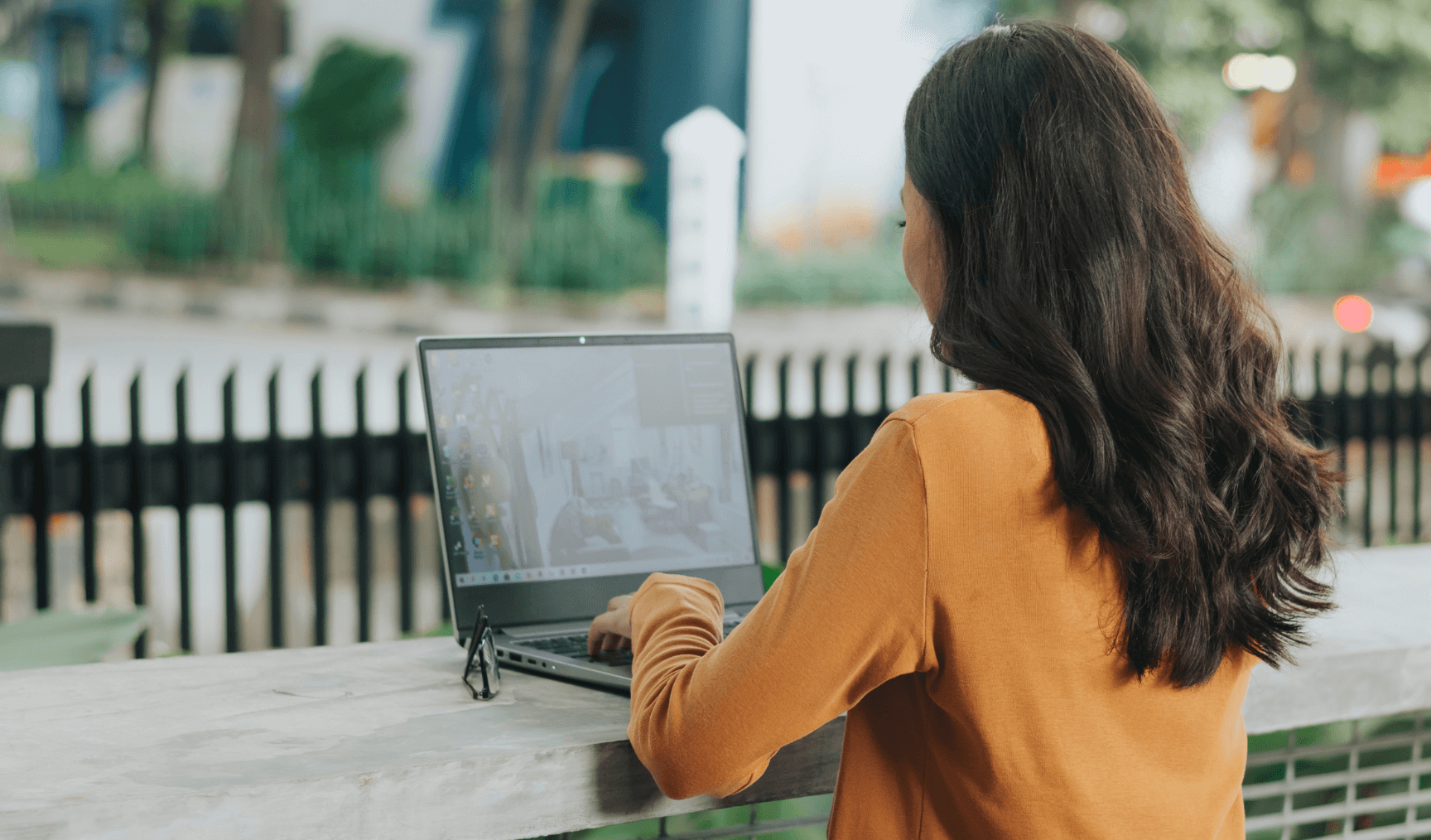 woman typing on her laptop while working outside
