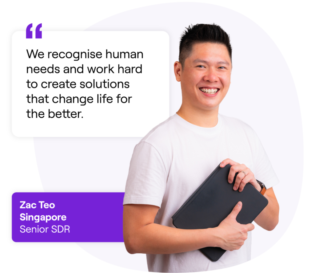 Smiling man with short black hair holding a tablet, wearing a white t-shirt and watch, next to a quote that reads: 'We recognise human needs and work hard to create solutions that change life for the better.' Text box below reads: 'Zac Teo, Singapore, Senior SDR.'