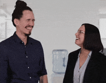 two colleagues fake laughing in office