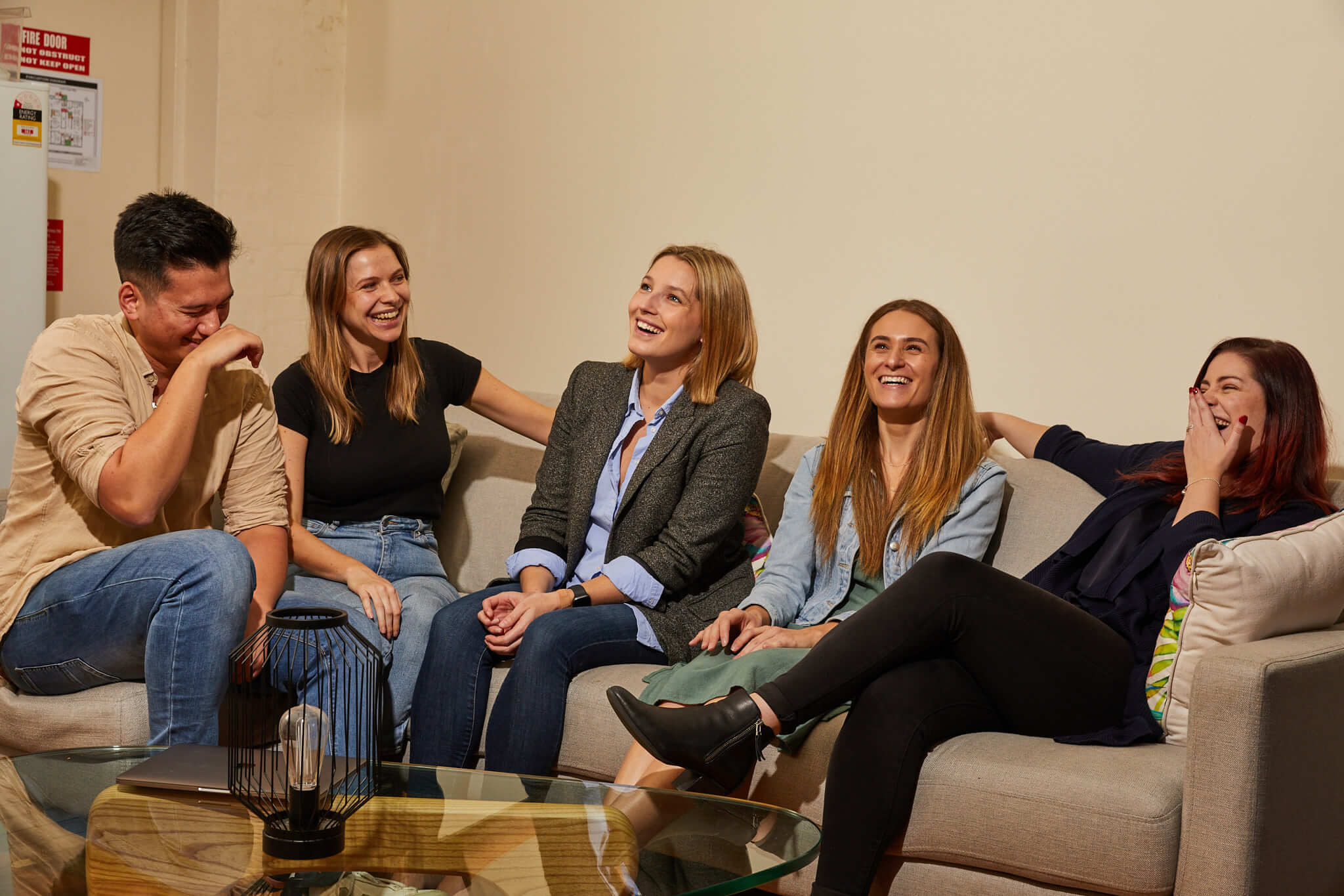 Team laughing on grey couch