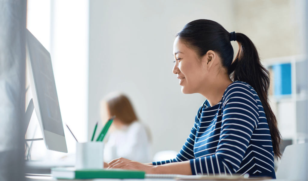 This is a photo of a woman sitting at a desk and smiling.