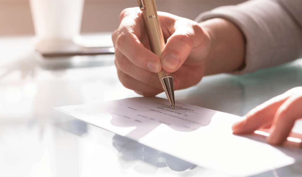 This is an image of a person writing on a piece of paper.