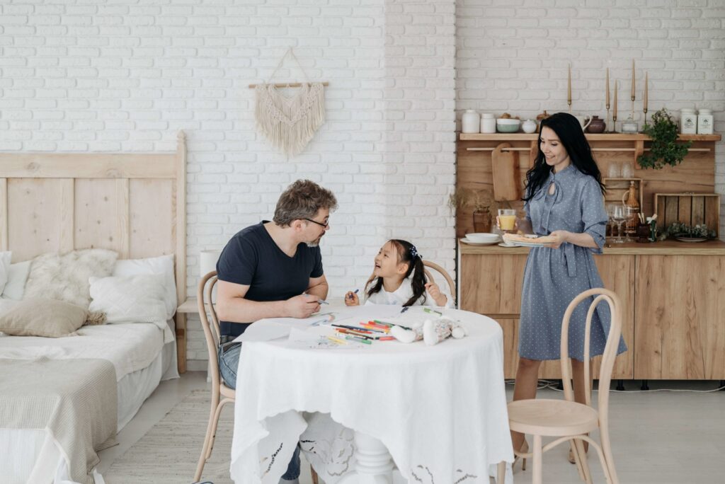 two parents having fun with their adopted kid at home