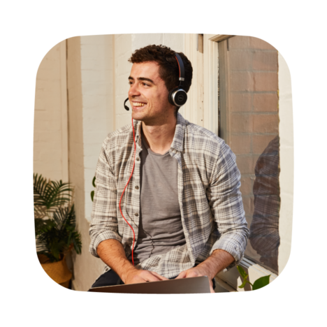 A man wearing a headphone and smiling.
