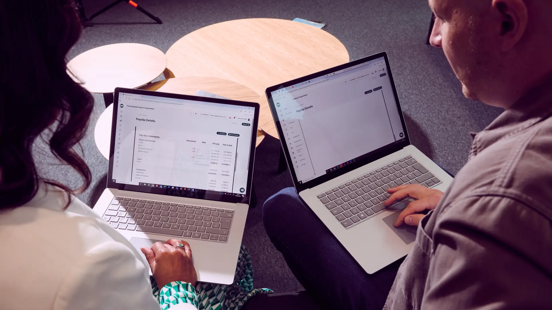 Overhead image of two colleagues typing on their laptops