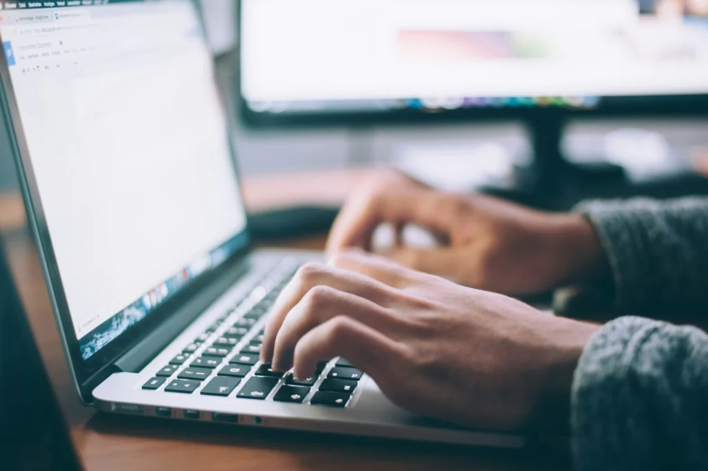 Close up of a pair of hands typing on the laptop