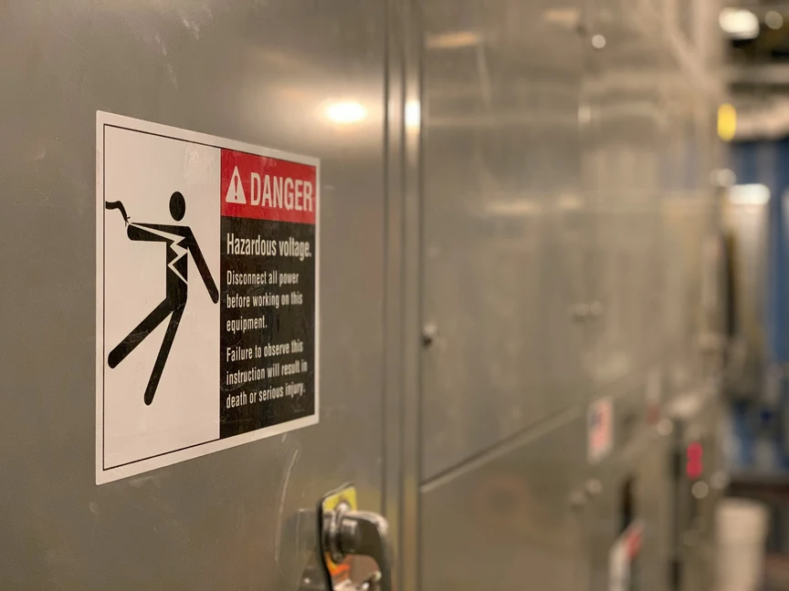 Danger sign warning of hazardous voltage on industrial electrical equipment.