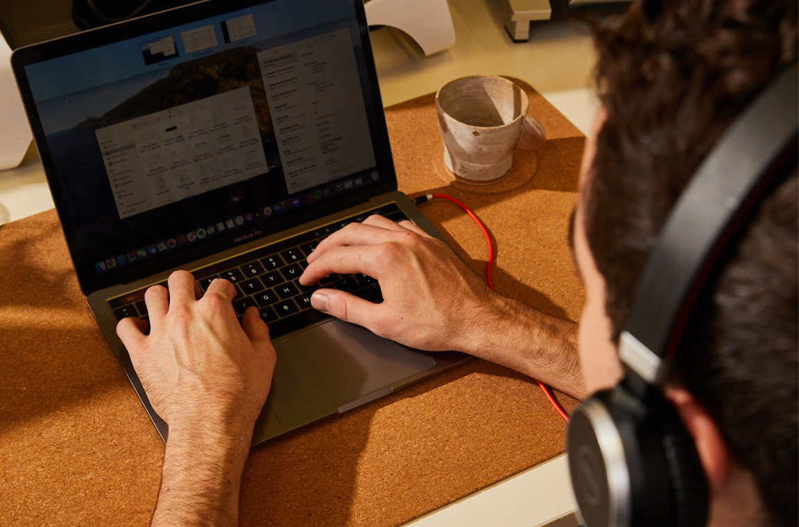 An employee is using his laptop and headphone while working remotely_Effective virtual onboarding experiences webinar_Employer Hero