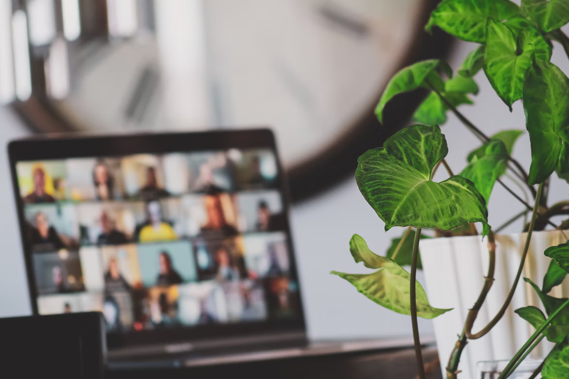 Laptop showing an ongoing zoom meeting in the background