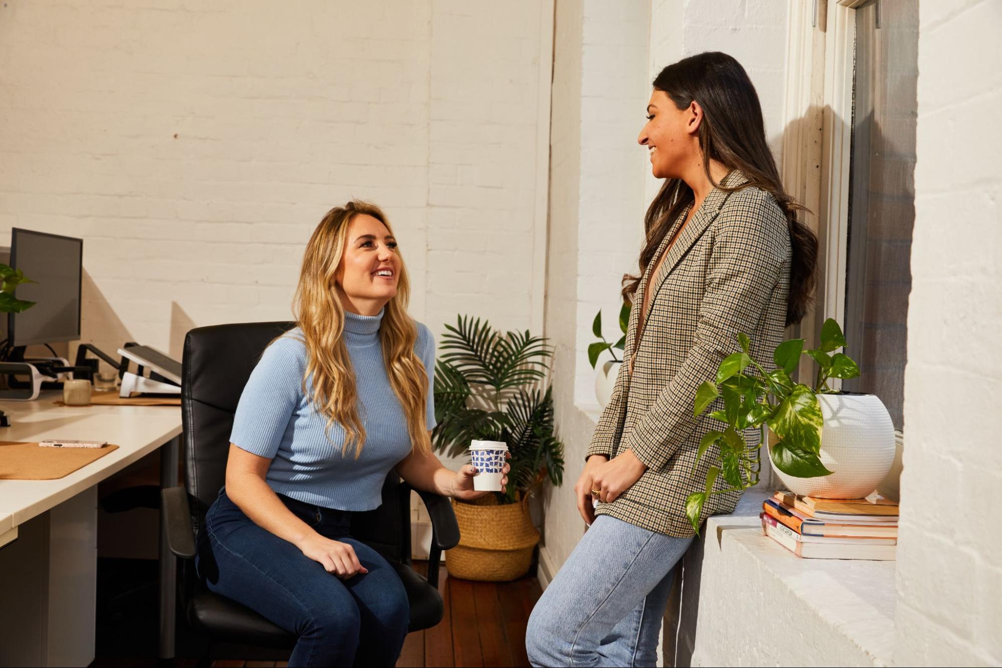 two colleagues chatting happily in the office