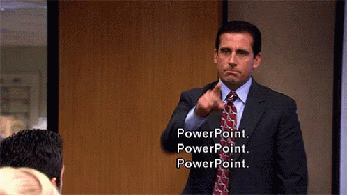 A man in a business suit points assertively while standing in a conference room. Text on-screen reads: "PowerPoint. PowerPoint. PowerPoint."