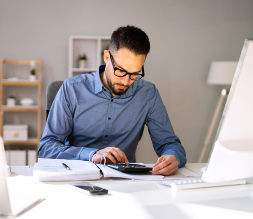 man working at his desk with the calculator