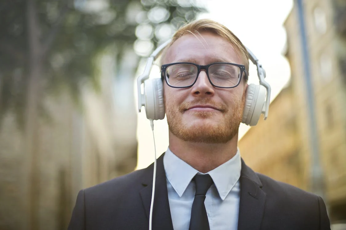 guy listening to music via headphones while walking along the street