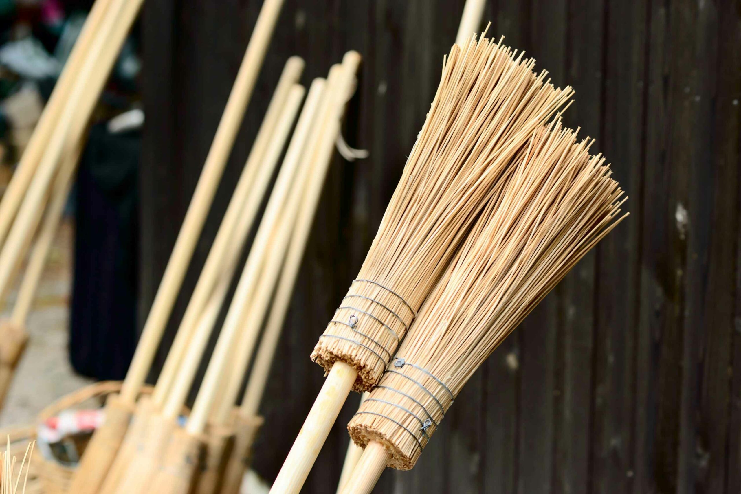 Several broomstick leaning up against a wall