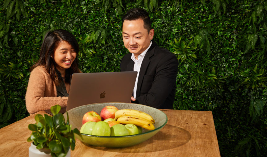 HR and a manager smiling and sitting at the table with a laptop.