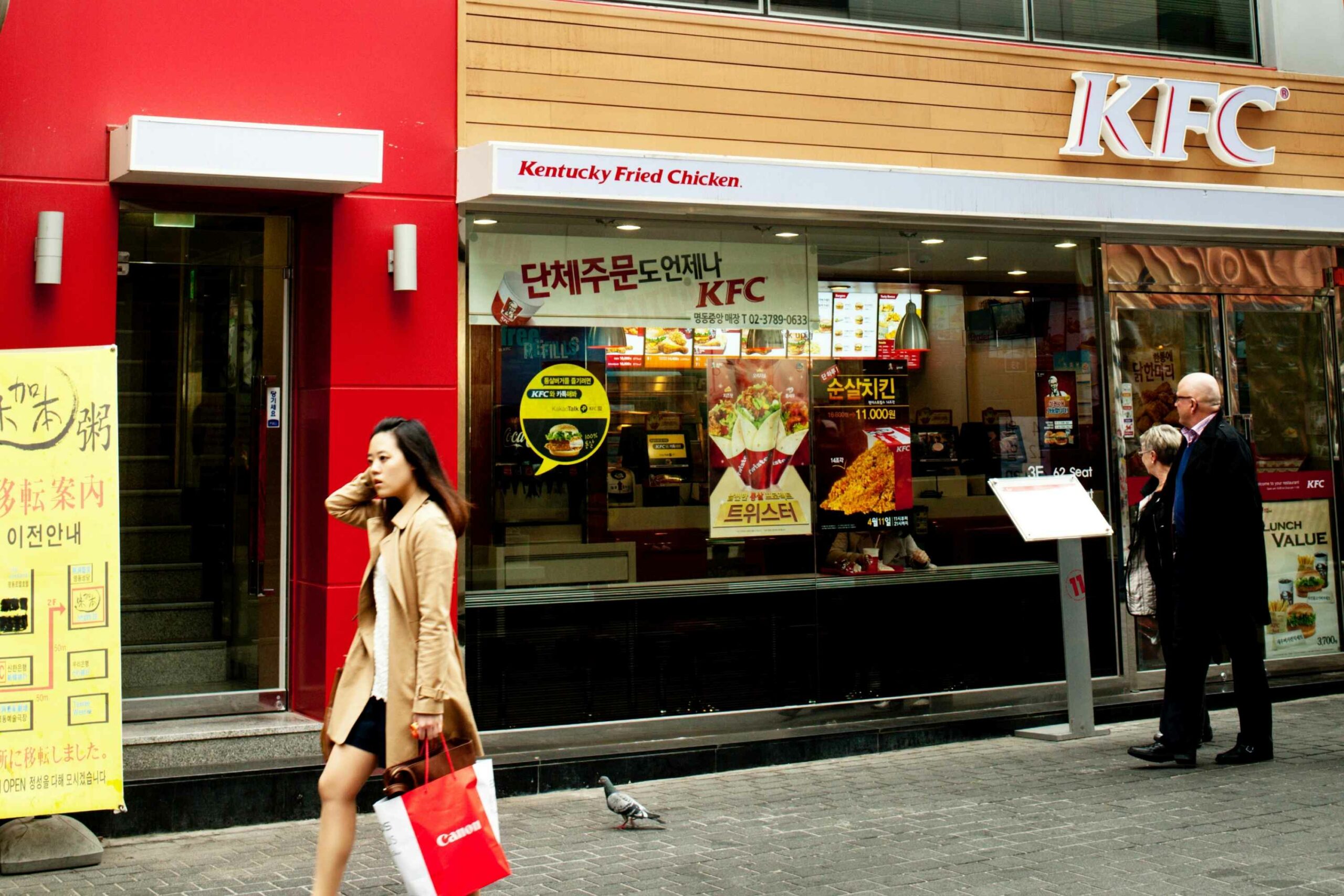 Woman walking past KFC store front