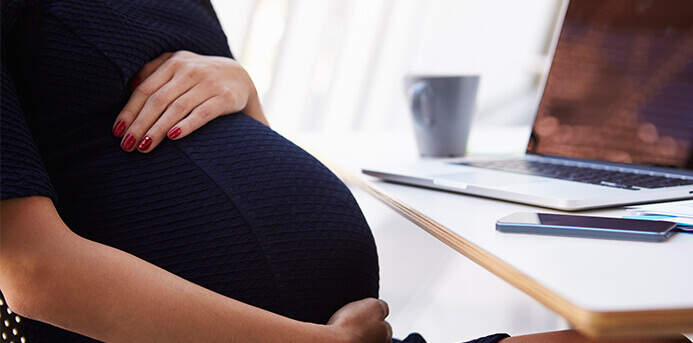 Image of a pregnant woman her work desk