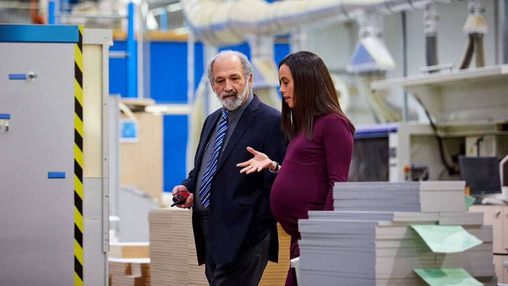 Image of a pregnant woman at work speaking with a co-worker