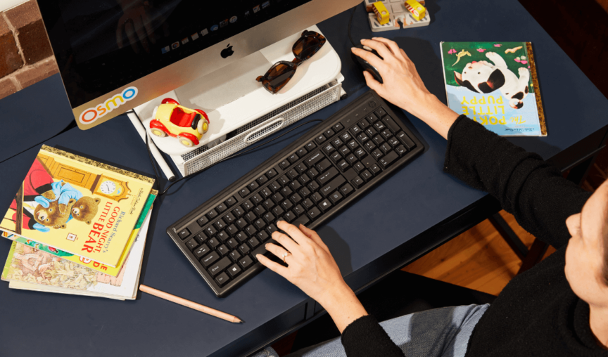 woman working at a desk surrounded by children's books