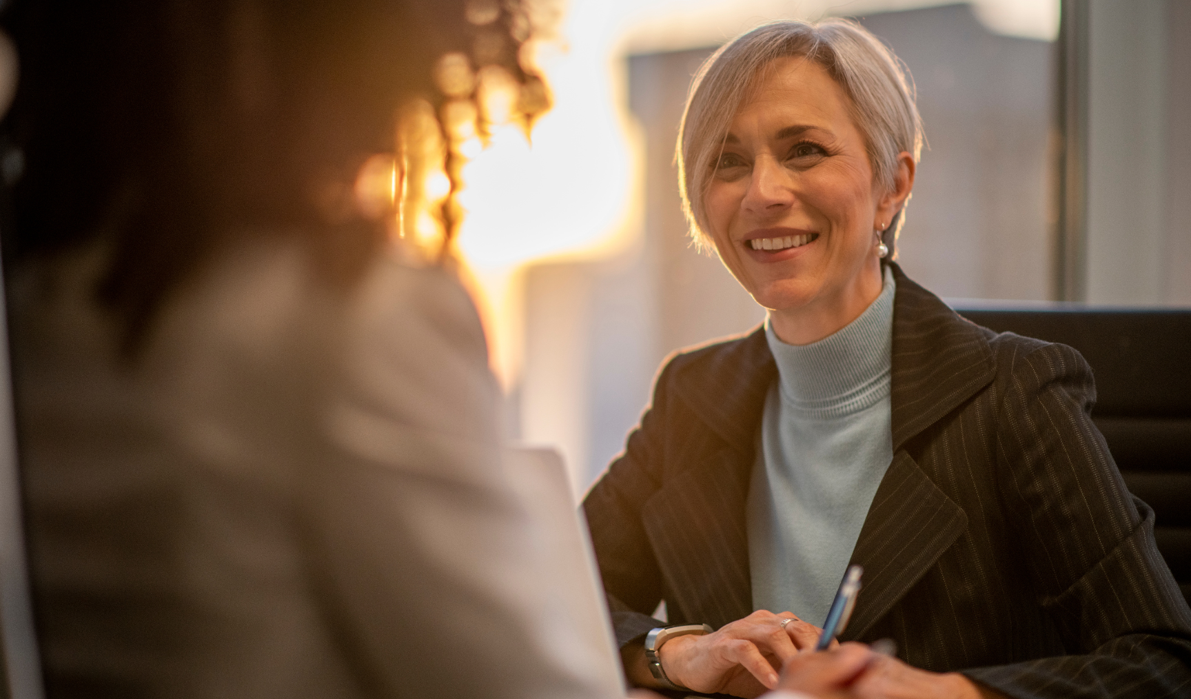 manager smiling at an employee during a chat in the office