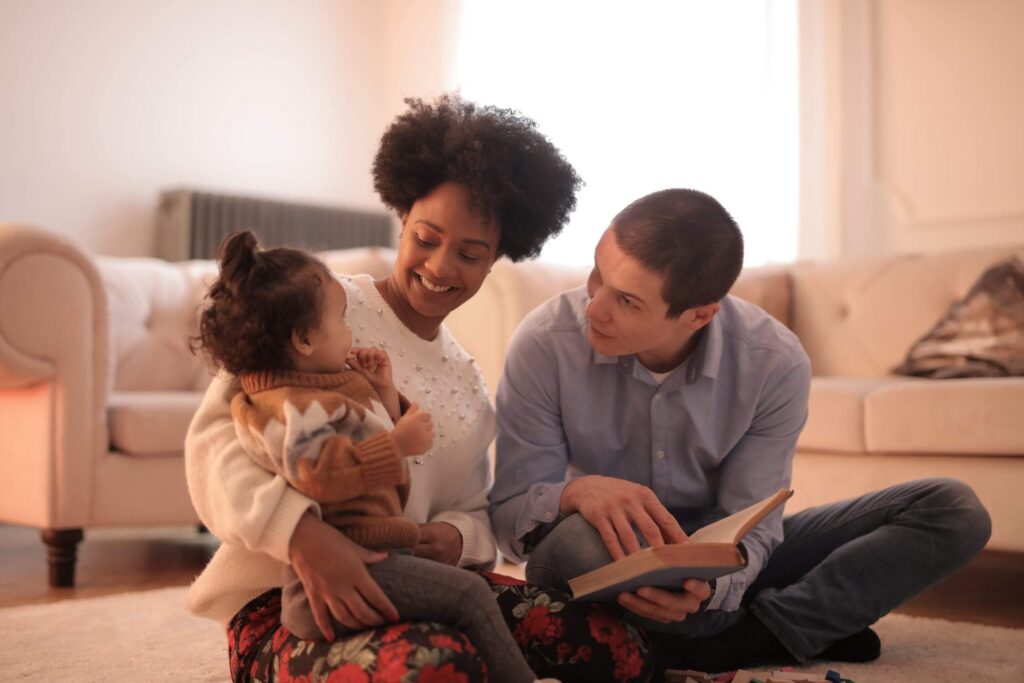 Image of new parents reading with this child