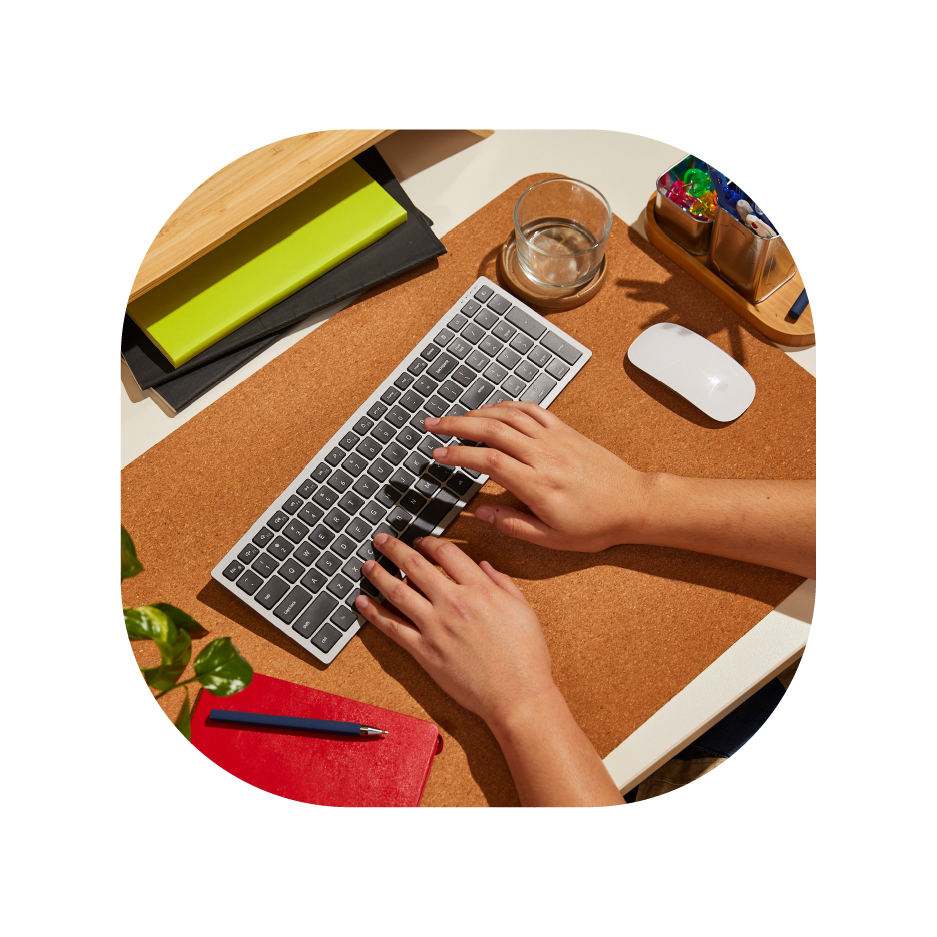Hands typing on a keyboard at a neat, organized desk