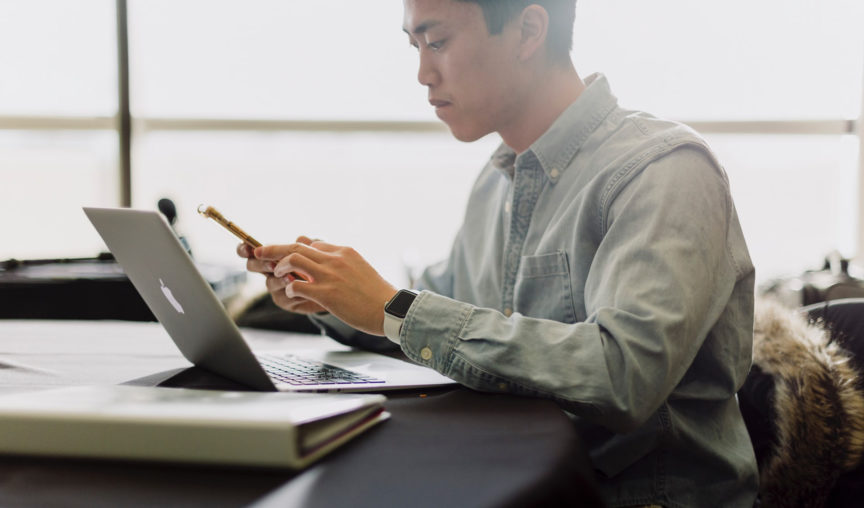 A man looking at his laptop looking at an HRIS