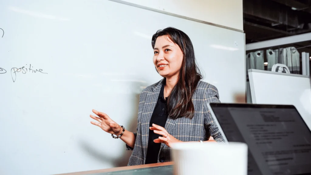 A woman in blazer, leading a meeting