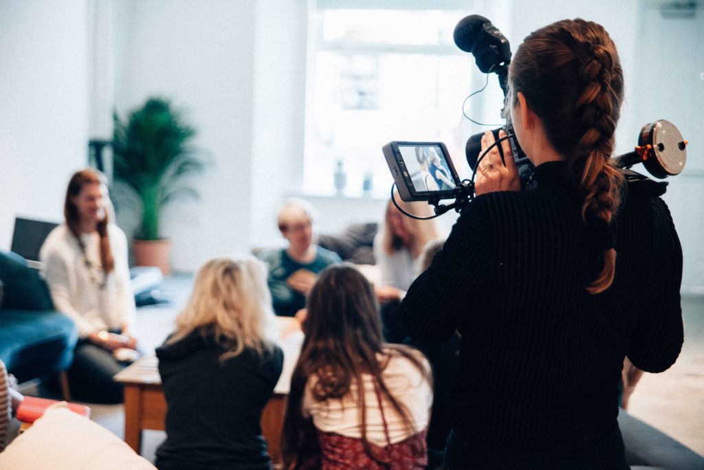 woman taking a video recording of the office team