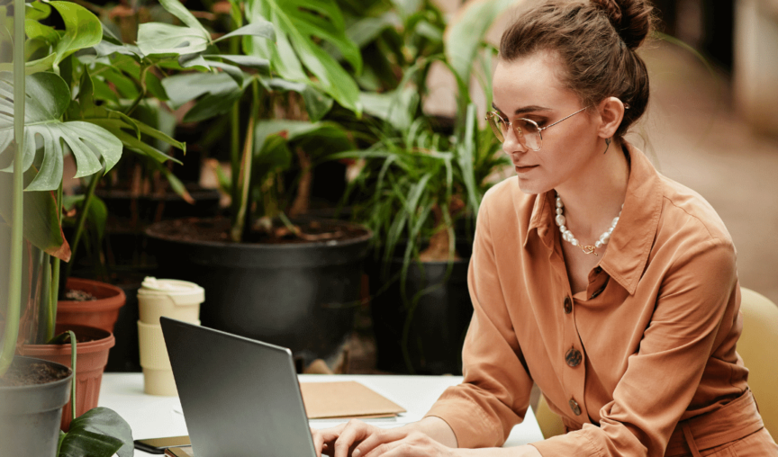 Image of a woman on her laptop look at the Employment Hero April Product Update 2022