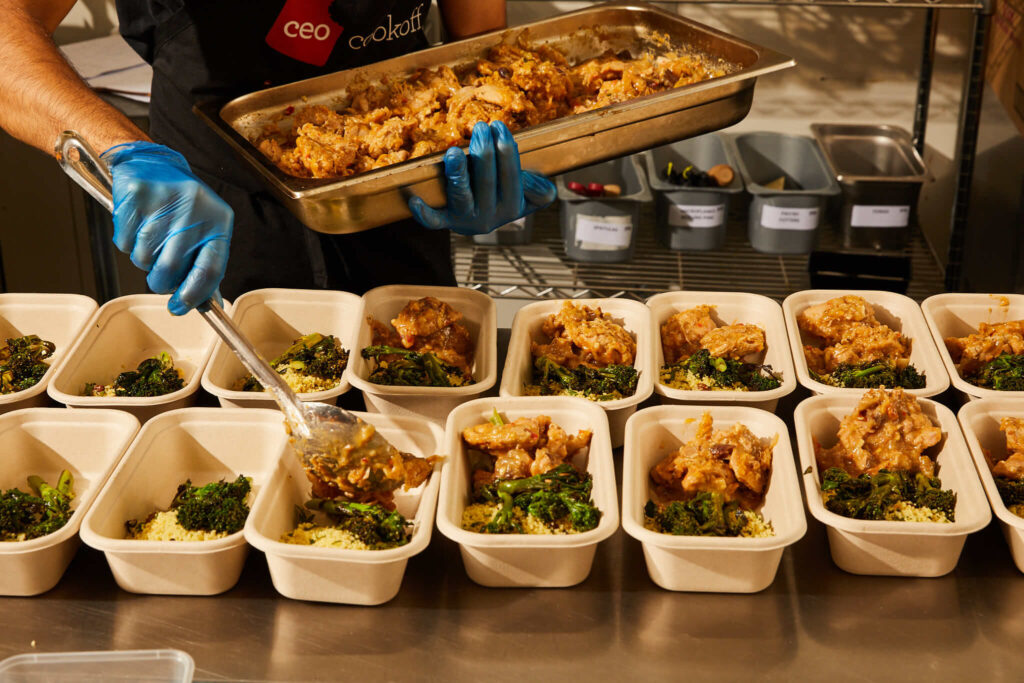 Skilled food server serving food into trays