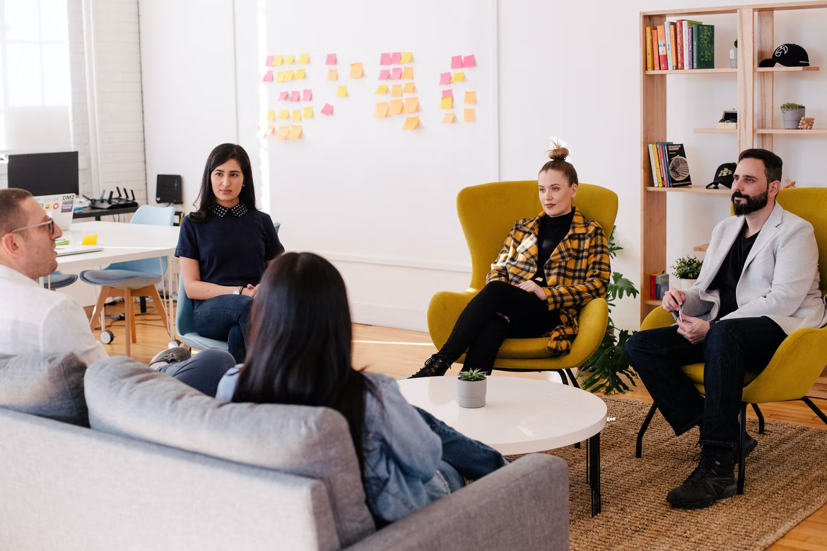 employees gathered in a circle sitting down and chatting