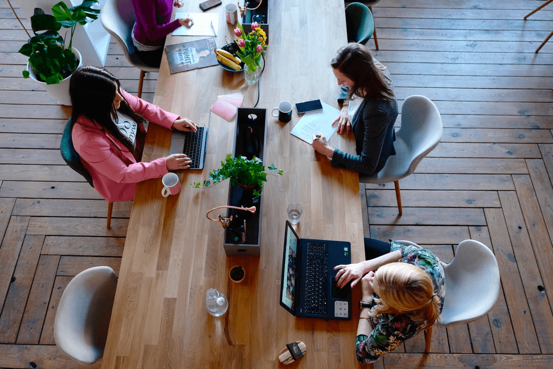 Employees sitting at a long table hot desking