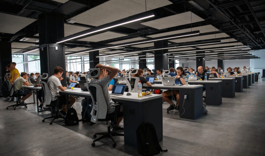 Employees sitting at hot desks in an office