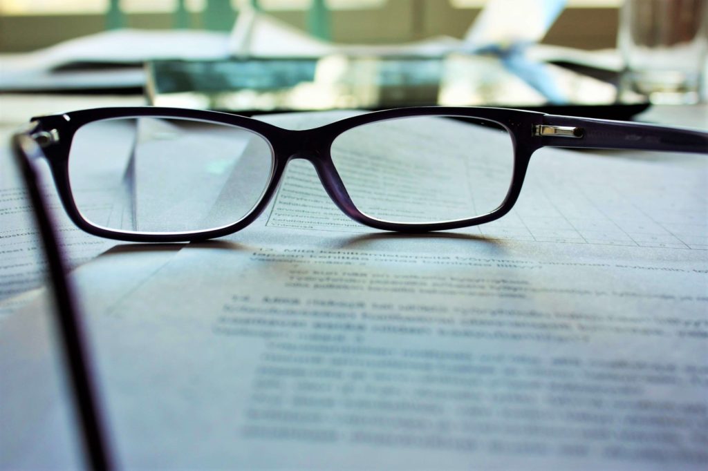 reading glasses on top of employment contracts