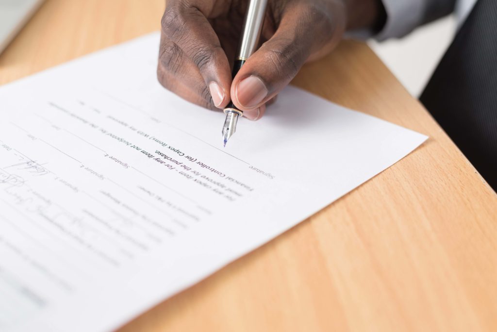 man signing a contract