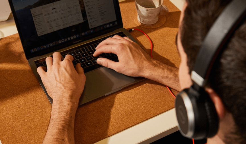 Man wearing headset typing on computer