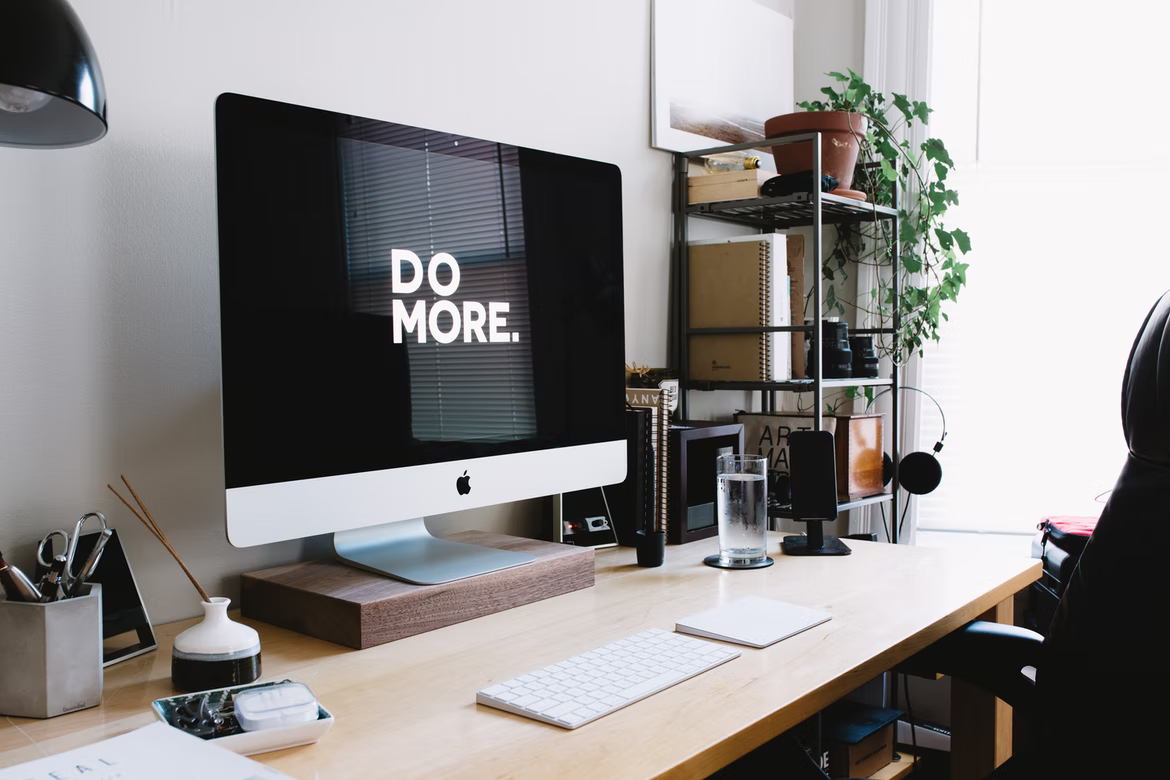 home office set up with a wallpaper on the computer saying do more