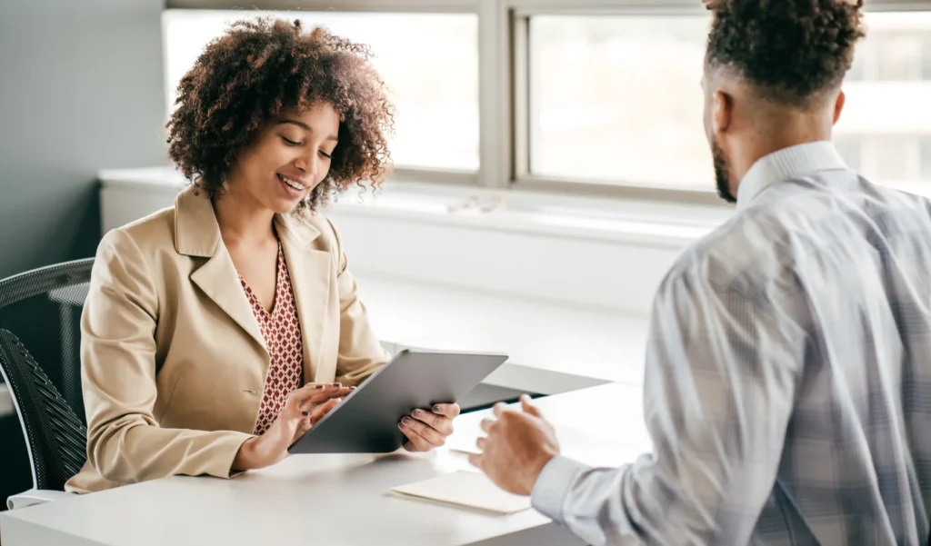 Employee smiling while reviewing a performance checklist during a performance review meeting.