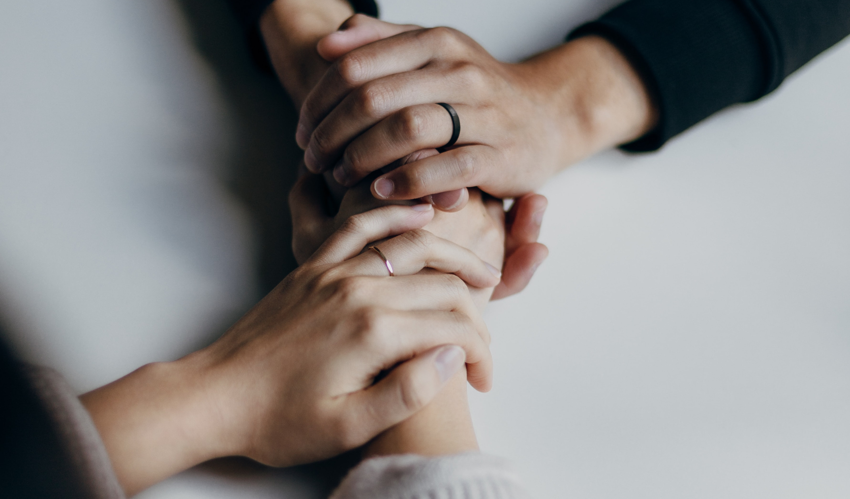 A person holding another person's hands comfortingly