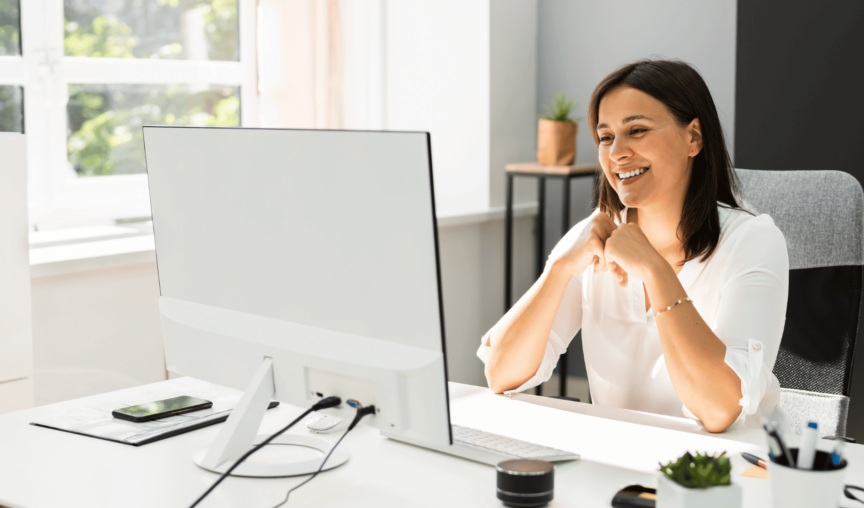 Woman working at her computer happily.