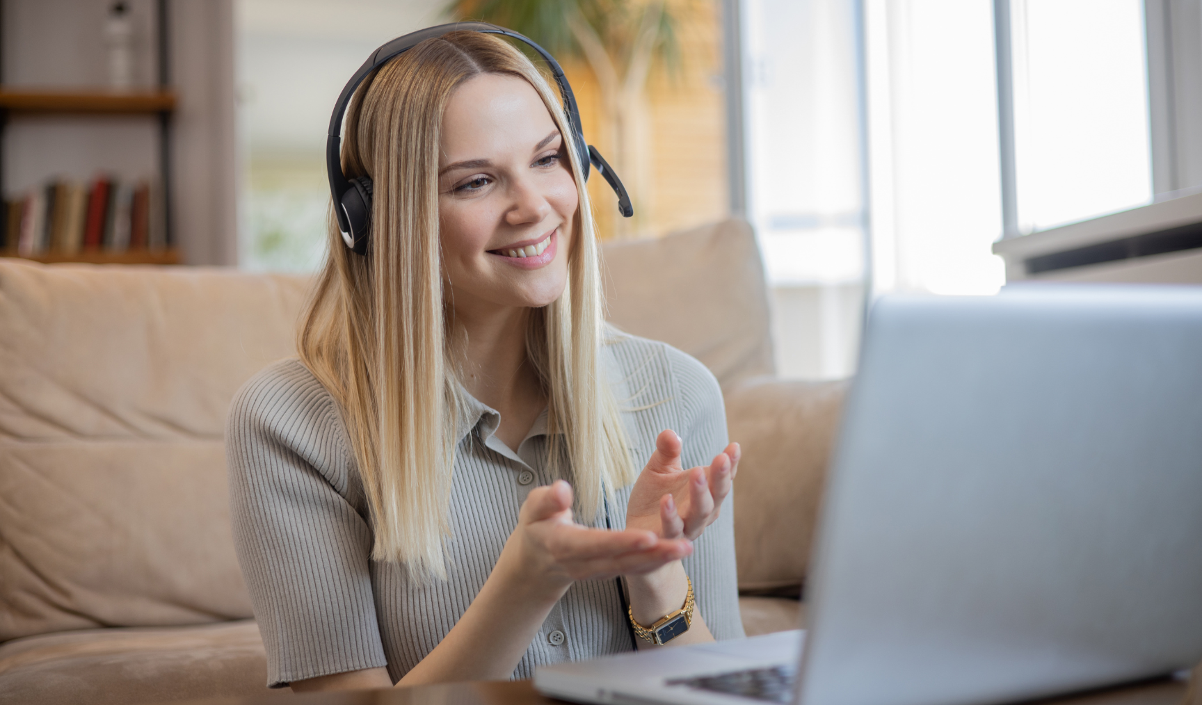 woman smiling while speaking to her laptop on a call