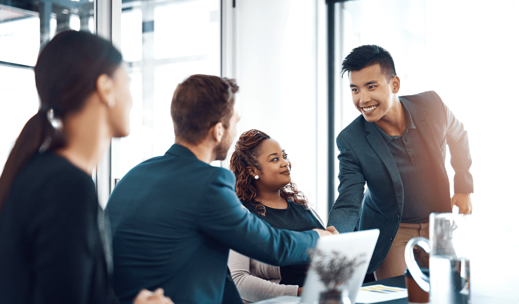 a group of employees where a man is shaking hands with another man