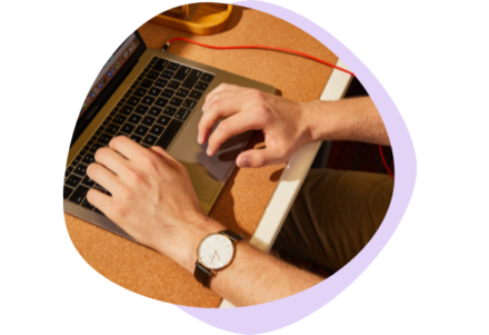 Close-up of two hands typing and scrolling on a laptop, actively engaging with the device.
