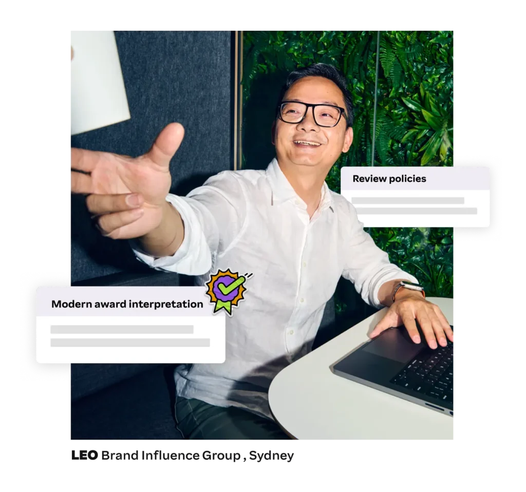 Smiling man handing a cup across a desk, with overlays reading “Modern award interpretation” and “Review policies.”